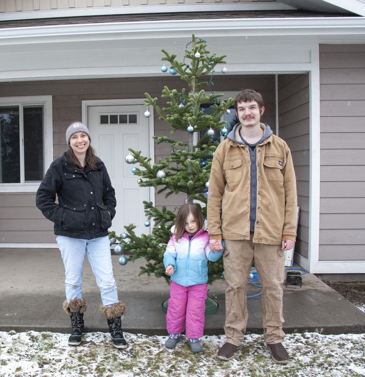 The Leaseburg family outside their home with a Christmas tree